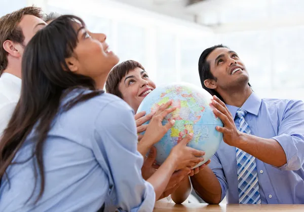 Международная бизнес-команда, держащая в руках термальный глобус — стоковое фото