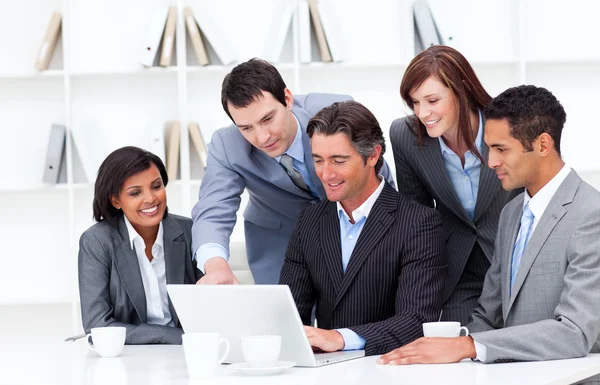 Equipe de negócios multicultural olhando para um laptop — Fotografia de Stock