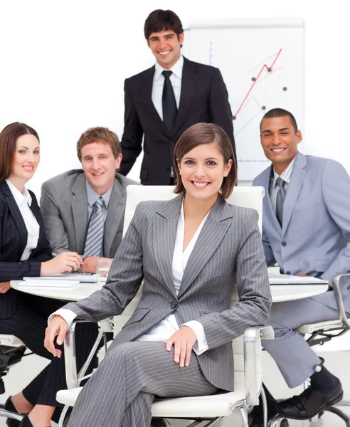 Assertive female executive sitting in front of her team — Stock Photo, Image