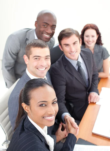 Sonriente equipo de negocios en una reunión estrechando las manos — Foto de Stock