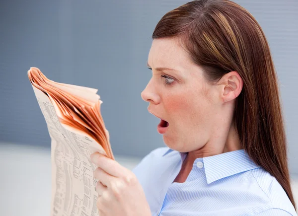 Erstaunte Geschäftsfrau liest Zeitung — Stockfoto
