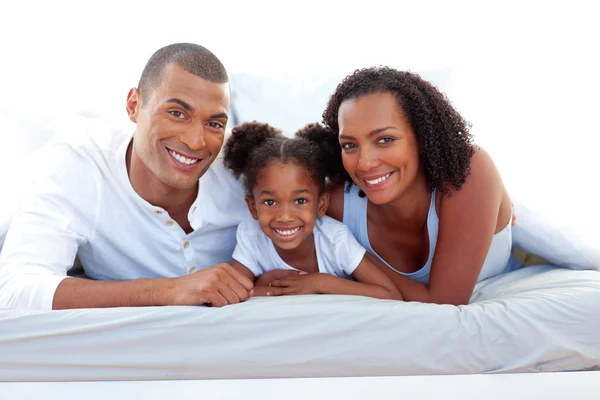 Kärleksfulla föräldrar och deras dotter som ler mot kameran — Stockfoto