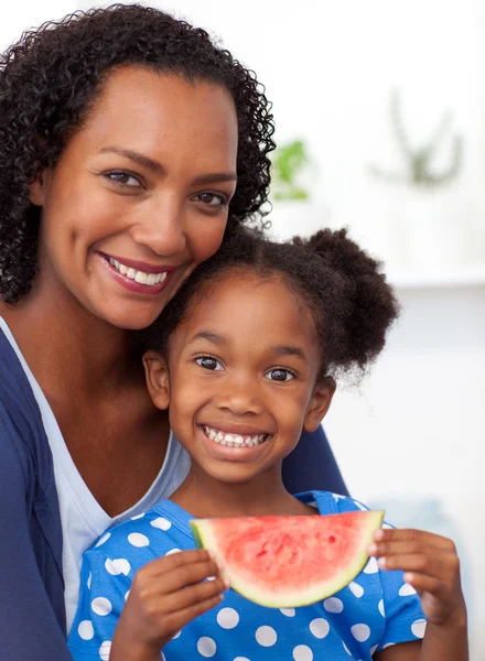 Sonriente madre y su hija comiendo fruta —  Fotos de Stock