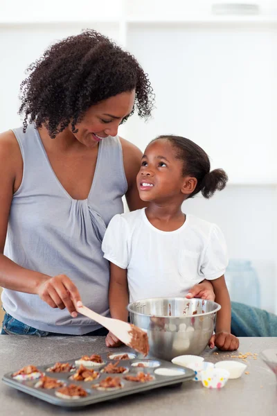 Mãe feliz ajudando sua filha cozinhar biscoitos — Fotografia de Stock