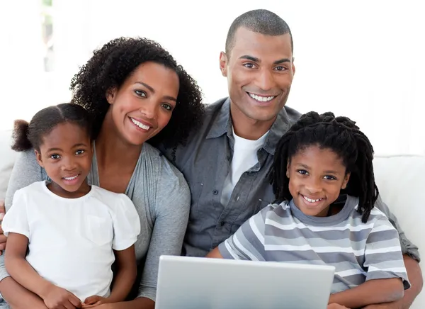 Familia afroamericana feliz usando un portátil en la sala de estar —  Fotos de Stock