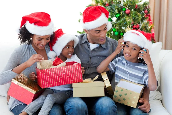 クリスマスで遊んで幸せなアフリカ系アメリカ人の家族を提示します。 — ストック写真