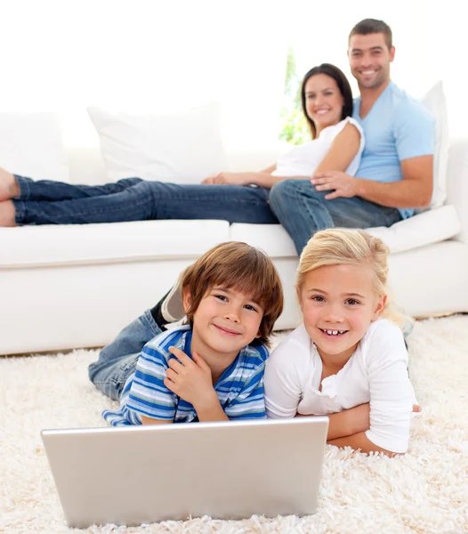 Любящая семья с ноутбуком в гостиной — стоковое фото
