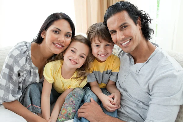 Portret uśmiechający się rodzina siedzi na kanapie — Zdjęcie stockowe