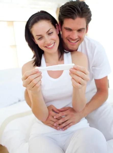 Lächelndes Paar erfährt Ergebnisse eines Schwangerschaftstests — Stockfoto