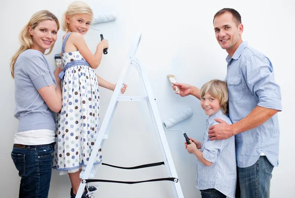 Felice famiglia pittura una stanza con i pennelli — Foto Stock