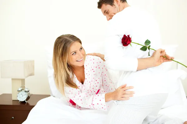 Homem atento dando uma rosa para sua esposa — Fotografia de Stock