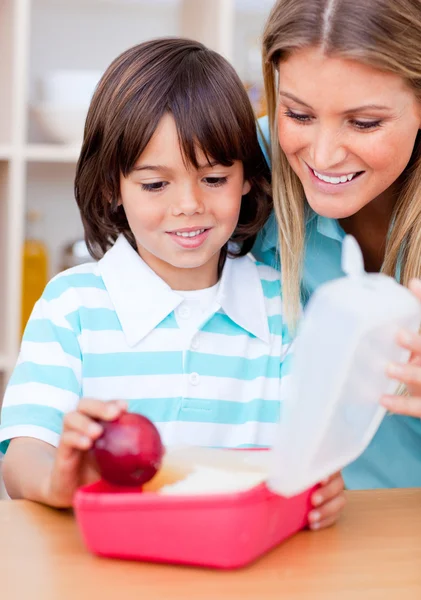 Smiling little boy and his mother preparing his snack — Stock Photo, Image