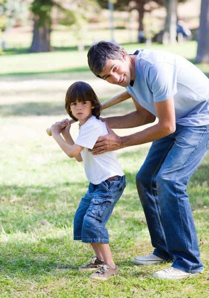 Улыбающийся отец учит своего сына бейсболу — стоковое фото
