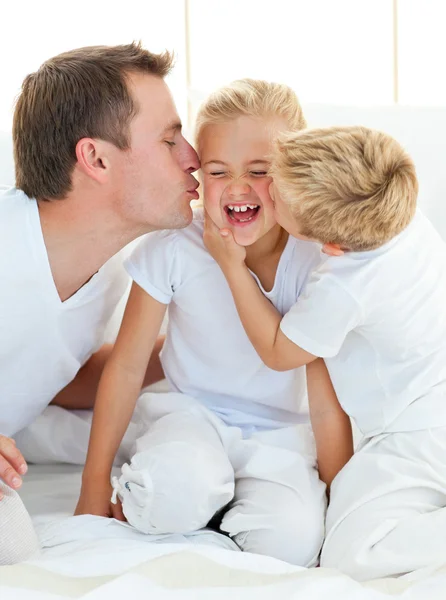 Loving family playing sitting on a bed — Stock Photo, Image
