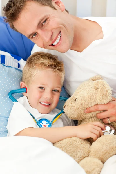 Bello padre e suo figlio malato che giocano con uno stetoscopio — Foto Stock