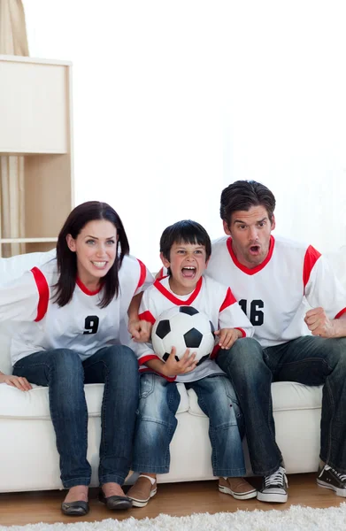 看一场足球比赛的动画的家庭 — 图库照片