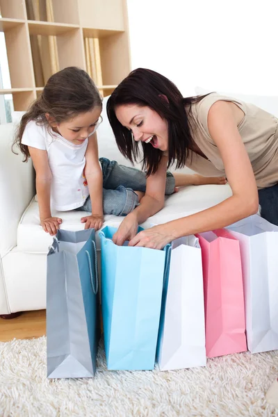 Mutlu anne ve kızı alışveriş torbaları açma — Stok fotoğraf