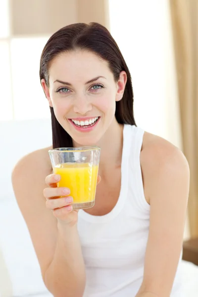 Donna sorridente bere succo d'arancia — Foto Stock