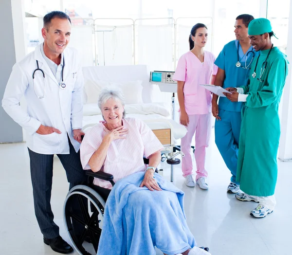 Positive medical team taking care of a senior woman — Stock Photo, Image