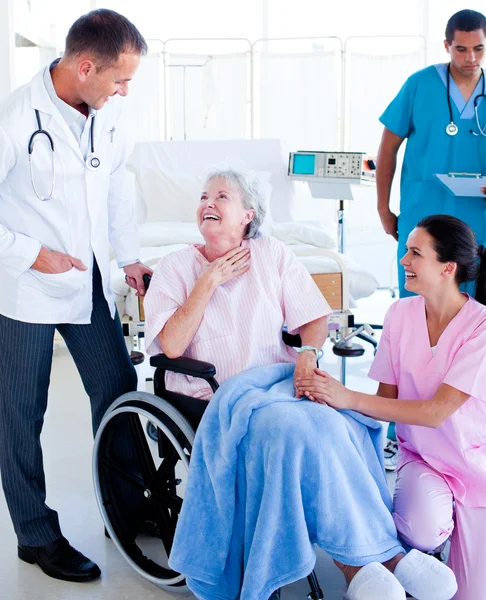 Selbstbewusstes Ärzteteam kümmert sich um eine Seniorin — Stockfoto