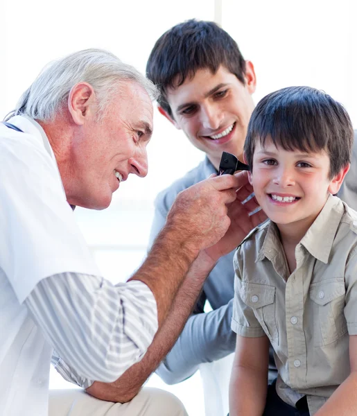 Médico sênior examinando os ouvidos de um menino — Fotografia de Stock