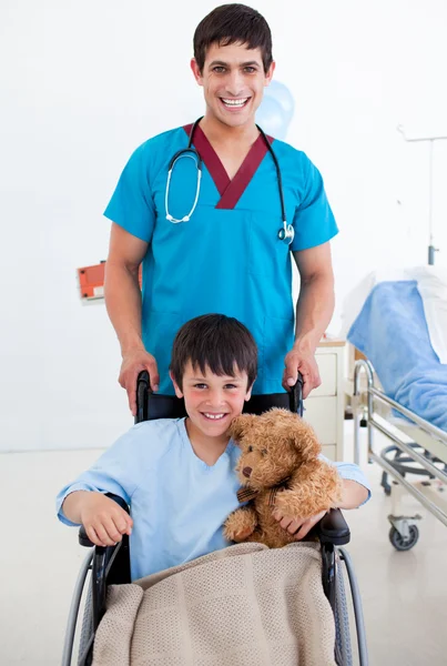 Портрет милого мальчика, сидящего на инвалидной коляске и врача — стоковое фото