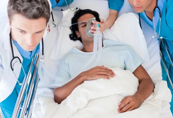 Doctors carrying a patient to intensive care unit — Stock Photo, Image