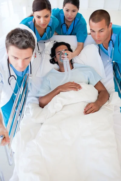 Equipo multiétnico de emergencia que lleva a un paciente —  Fotos de Stock