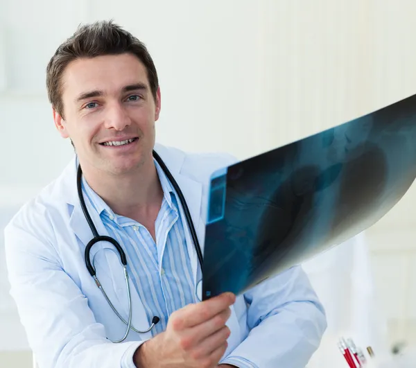 Attractive doctor examining an x-ray — Stock Photo, Image