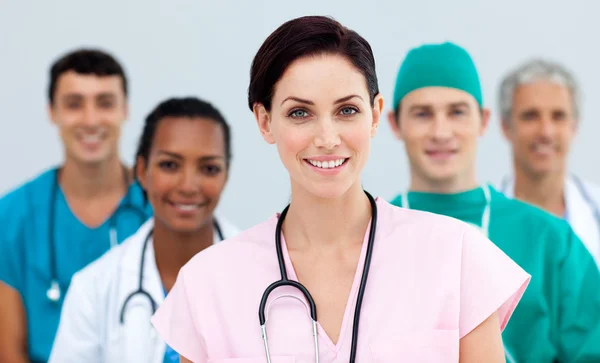 Médica em pé na frente de sua equipe — Fotografia de Stock