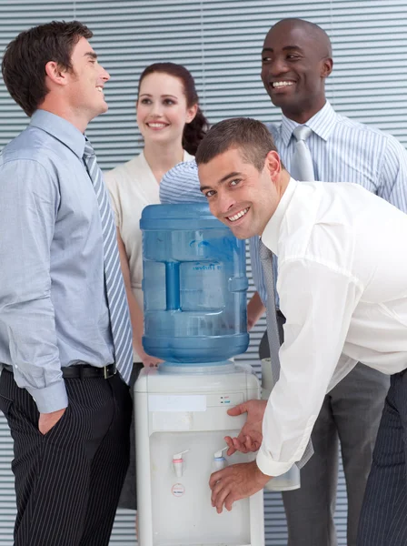 Compañeros de negocios hablando en torno a enfriador de agua —  Fotos de Stock