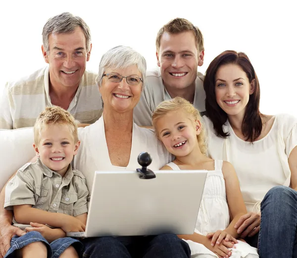Família feliz usando um laptop em casa — Fotografia de Stock