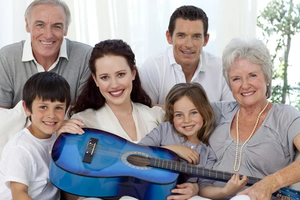 Портрет семьи, держащей гитару в гостиной — стоковое фото
