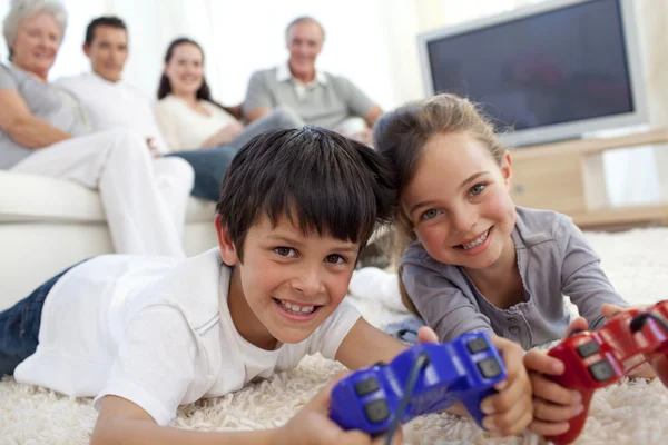 Crianças jogando videogames e família no sofá — Fotografia de Stock