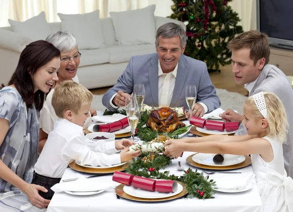 Children pulling a Christmas cracker at home — Stock Photo, Image
