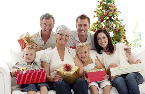 Family holding Christmas presents at home — Stock Photo, Image