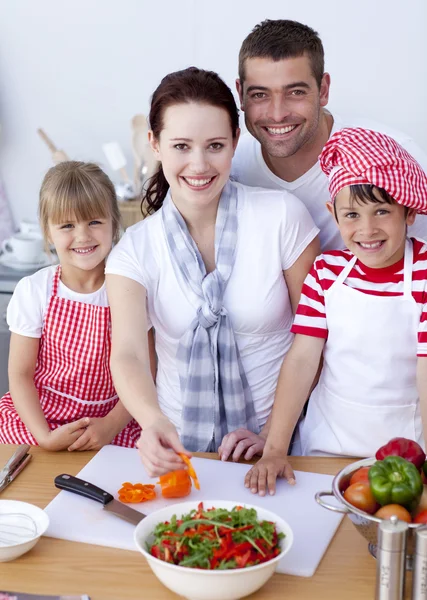 Família de corte de pimentas coloridas na cozinha — Fotografia de Stock