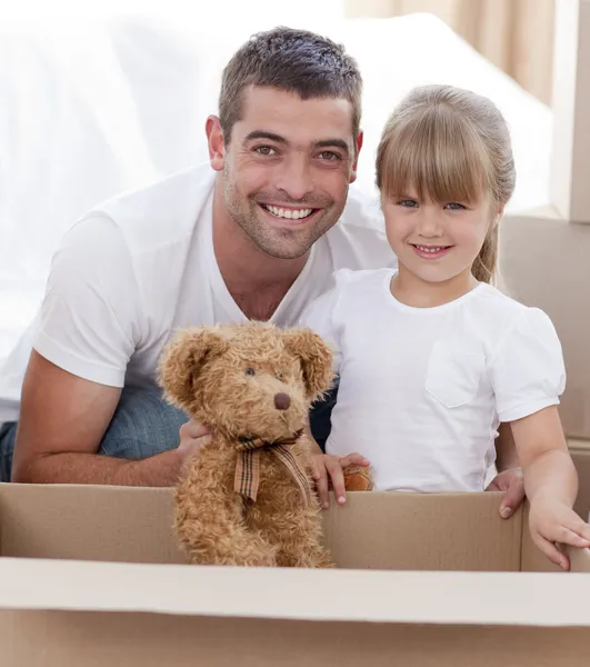 Padre e hija con un oso de peluche mudándose a casa — Foto de Stock