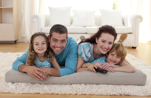 Famiglia sorridente al piano in soggiorno — Foto Stock