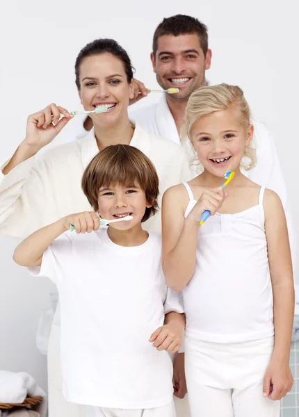 Pais e crianças limpando os dentes no banheiro — Fotografia de Stock
