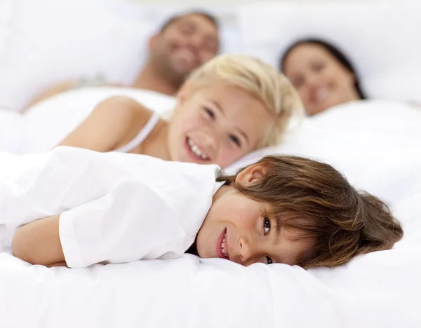 Семья отдыхает в кровати родителей — стоковое фото