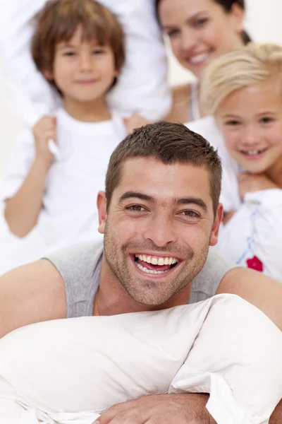 Family having a pillow fight in bed — Stock Photo, Image