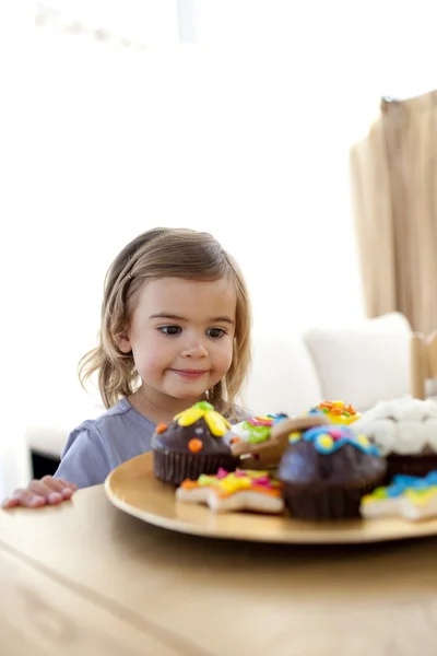 Little girl looking at confectionery at home — Stock Photo, Image