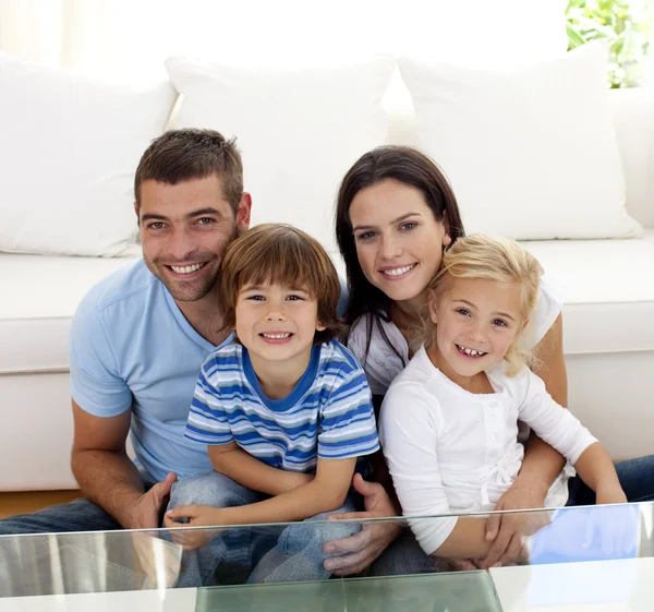 Retrato de família feliz sorrindo na sala de estar — Fotografia de Stock