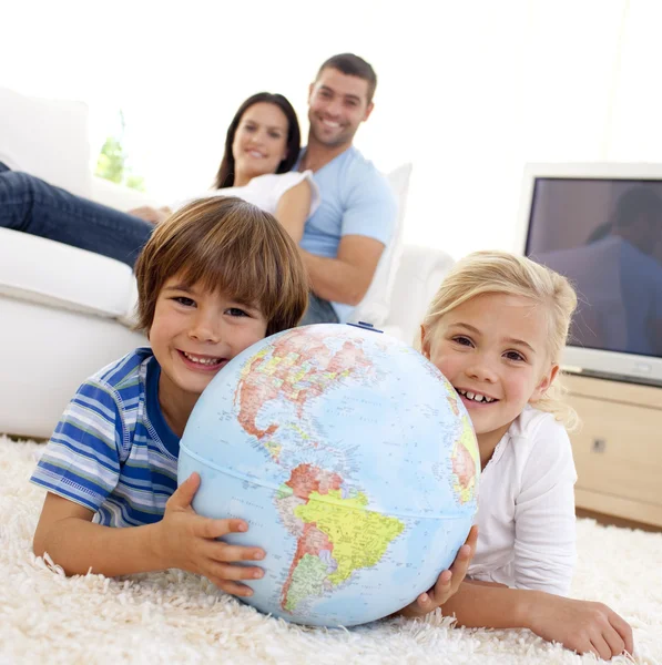 Children playing with a terrestrial globe at home — Stock Photo, Image