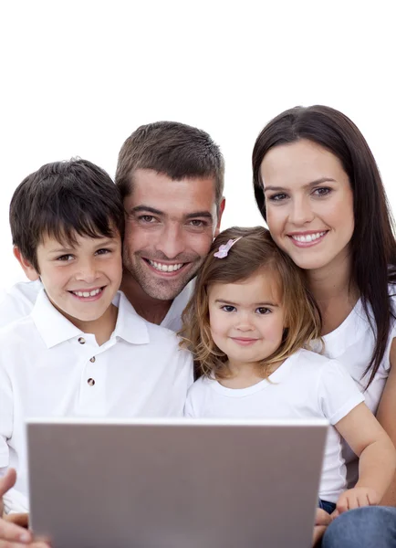 Retrato de una familia joven usando un portátil en casa — Foto de Stock