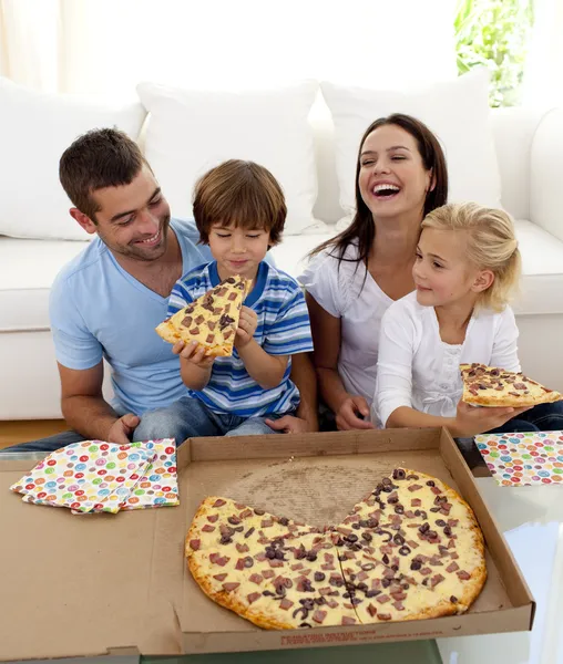 Padres e hijos comiendo pizza en el salón —  Fotos de Stock