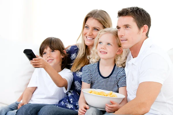 Famille souriante regardant un film à la télévision — Photo