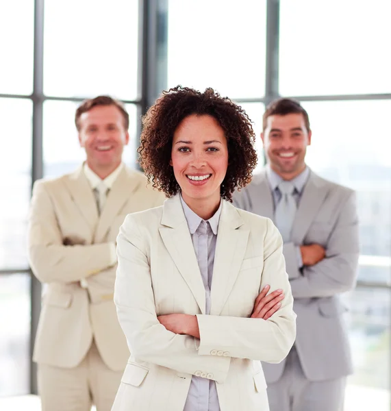 Mulher de negócios sorridente com sua equipe em segundo plano — Fotografia de Stock
