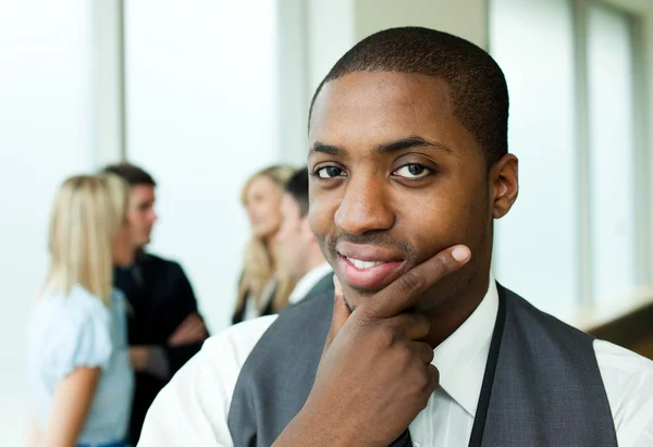 Doordachte etnische zakenman glimlachen naar de camera — Stockfoto